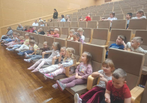 dzieci siedzą oglądając koncert