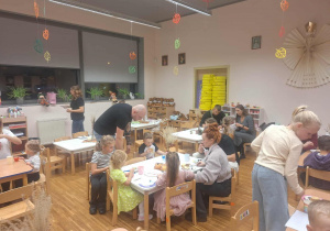 rodzice i dzieci siedzą przy stolikach