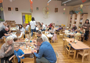 rodzice i dzieci siedzą przy stolikach