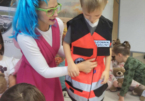 Chłopiec przymierza kamizelkę ratownika medycznego