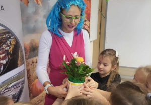 Dzieci wręczają wróżce kwiatka