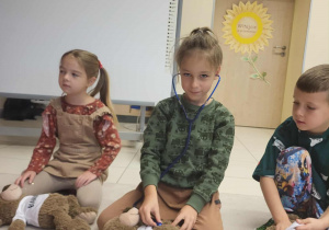 Chłopiec bada stetoskopem swojego misia