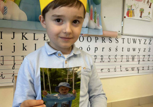 Chłopiec pokazuje zdjęcie z dzieciństwa