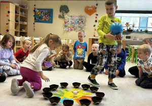 Chłopiec trzyma globus a dziewczynka rozkłada koraliki