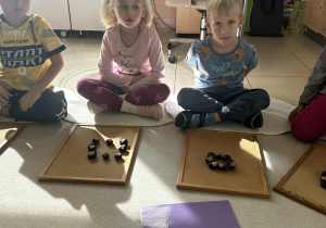 Dzieci układają figury geometryczne z darów jesieni