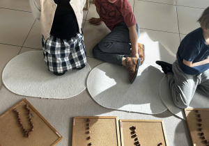 Dzieci układają cyfrę 1 z kasztanów