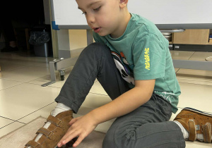 Chłopiec tworzy naturalną linijkę z kasztanów