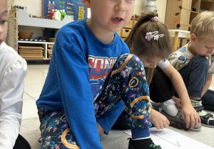 Chłopiec tworzy naturalną linijkę z kasztanów