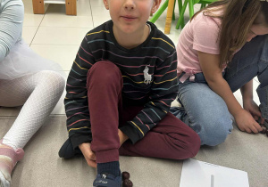 Chłopiec tworzy naturalną linijkę z kasztanów