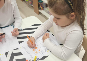 Dziewczynka rozwiązuje kartę pracy o kodowaniu