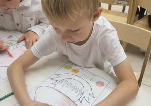 Chłopiec rozwiązuje kartę pracy o kodowaniu