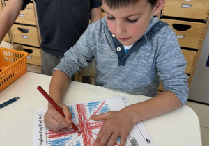 chłopiec maluje według wzoru kodowania flage Wielkiej Brytanii