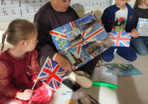 nauczycielka pokazuje dzieciom plakat z zabytakami Wielkiej Brytani