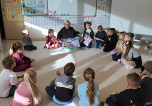 dzieci siedzą w kole z nauczycielka i słuchają inoformacji o Wielkiej Brytanii