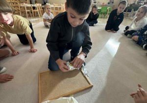 chłopiec odpakowywuje z foli aluminiowej owoc