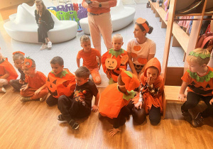 dzieci wraz z pania siedzą na podłodze