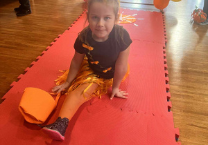 dziewczynka robi szpagat na wybiegu i prezentuje swój strój