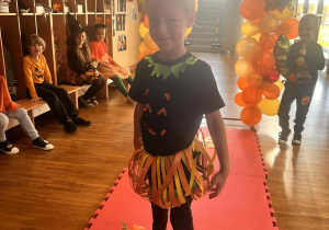 chłopiec stoi na wybiegu i pozuje do zdjęcia prezętując swój strój