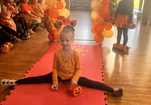 dziewczynka na wybiegu robi szpagat