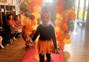 dziewczynka idzie po wybiegu prezentując swój dyniowy strój