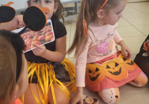 dzieci oglądają ilustracje dyń