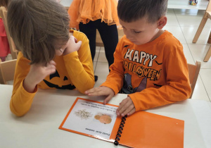 chłopcy oglądają książeczkę o dyni