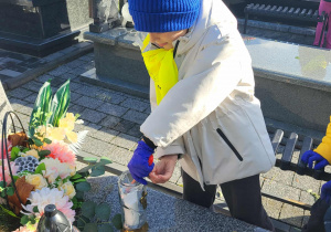 chłopiec zapala znicz