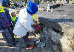 chłopiec czyści grób