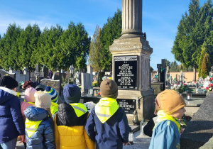 dzieci stoją przy grobie