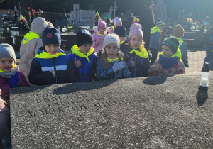 dzieci stoją przy grobowcu