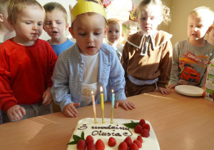 chłopiec zdmuchuje świeczki
