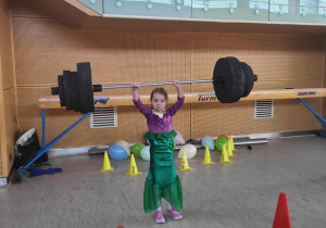 dziewczynka podnosi sztangę