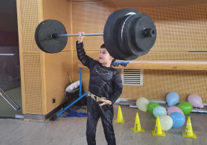 chłopiec podnosi sztangę