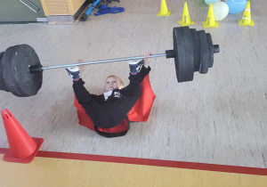 chłopiec pokazuje podnoszenie sztangi nogami