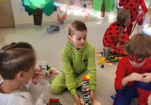 grupa chłopców buduje z klocków nos Pinokia