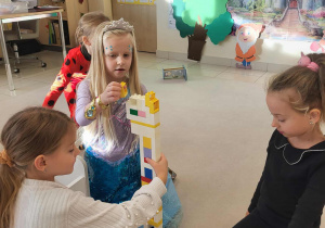 grupa dziewczyn buduje z klocków nos Pinokia