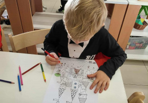 chłopiec koloruje malowankę