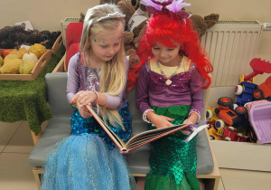 dziewczynki oglądają książeczkę