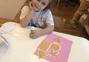 dziewczynka przykleja papierowe pierniczki