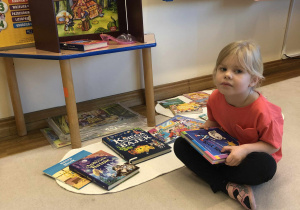 dziewczynka ogląda książki