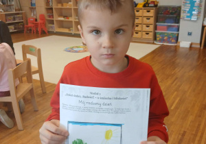 Chłopiec prezentuje swoją pracę