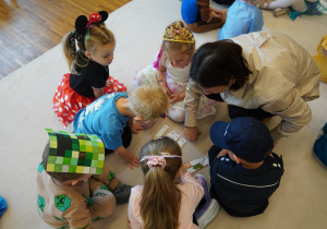 dzieci układają z panią Magdą puzzle