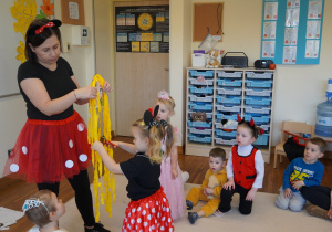 dziewczynka obcina włosy z żółtej bibuły