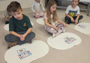 dziewczynka czyta ułożony z literek wyraz