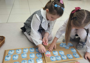 dziewczynki łączą słoik z nakrętką szukając małej i wielkiej literki