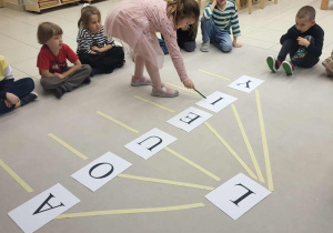 dziewczynka pokazuje literkę