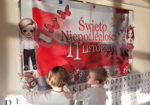 chłopcy ozdabiają tablicę