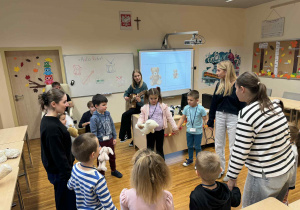 dzieci chodzą w kole,trzyamjąc się za ręcę wraz z uczniami i śpiewają piosenke