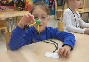 chłpiec trzyma zbudowaną przez siebie molekułe wody