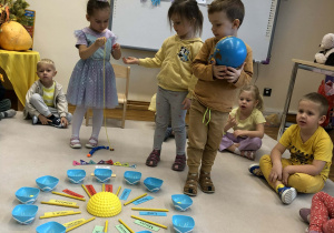 dzieci chodzą wokół urodzinowego słoneczka